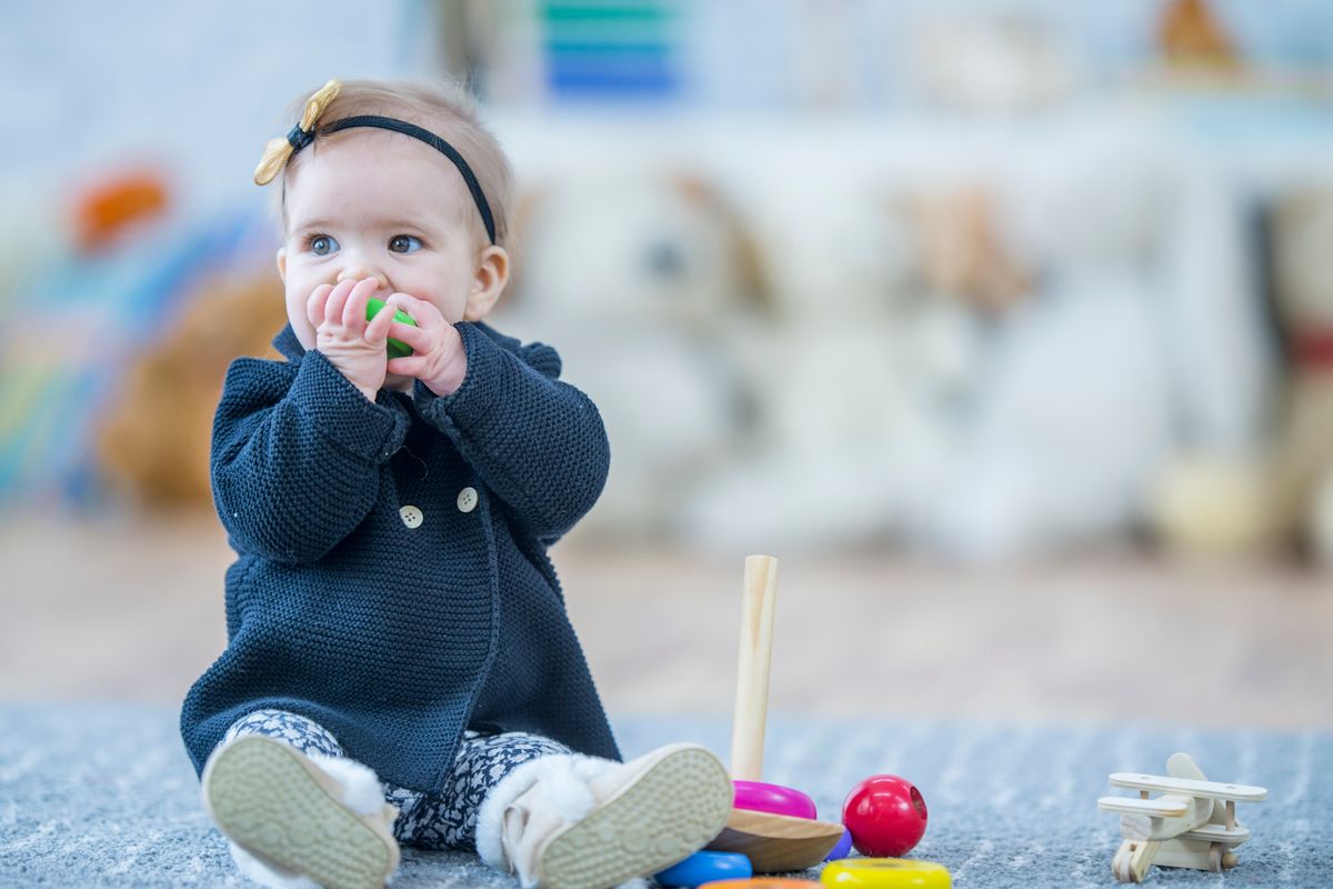 Egy kislány éppen a szájába vesz egyet a veszélyes gyerekjátékok közül. 
