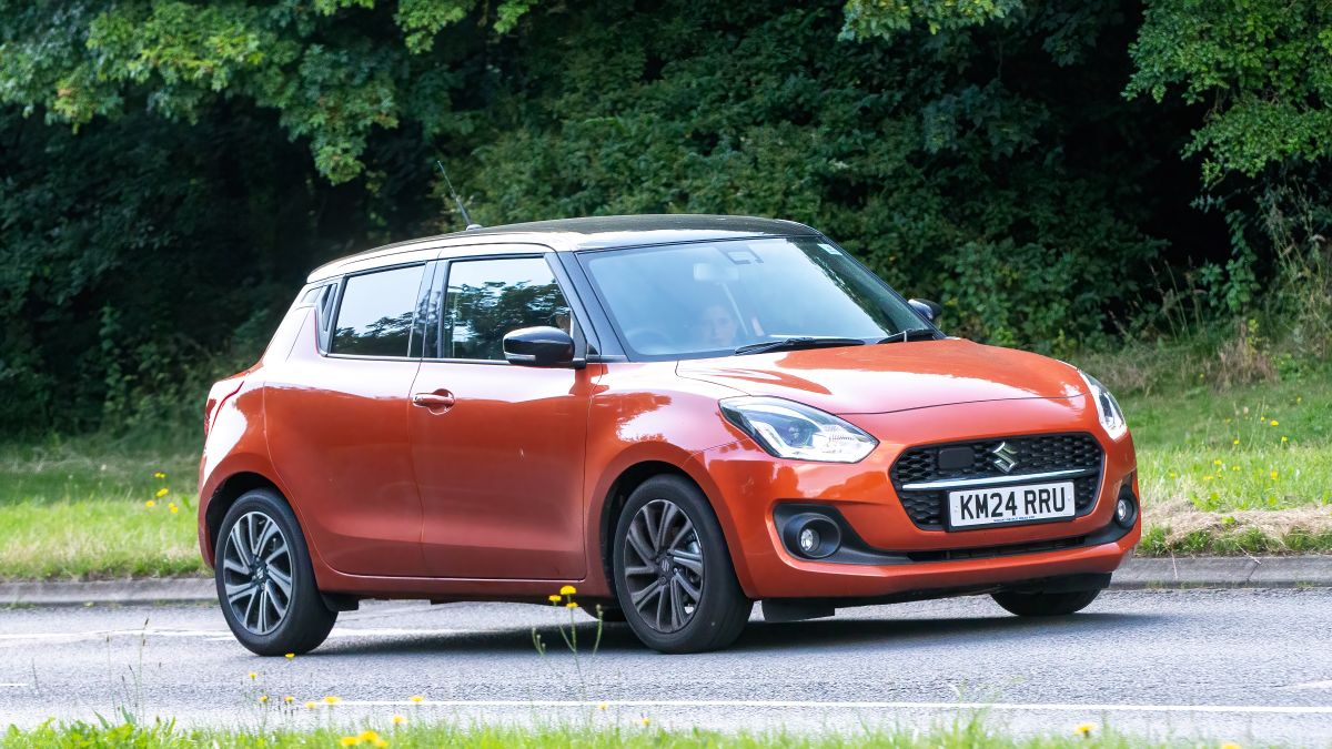 Milton Keynes,UK - July 18th 2024: 2024 orange hybrid electric Suzuki Swift SZ5  car driving on a British country road