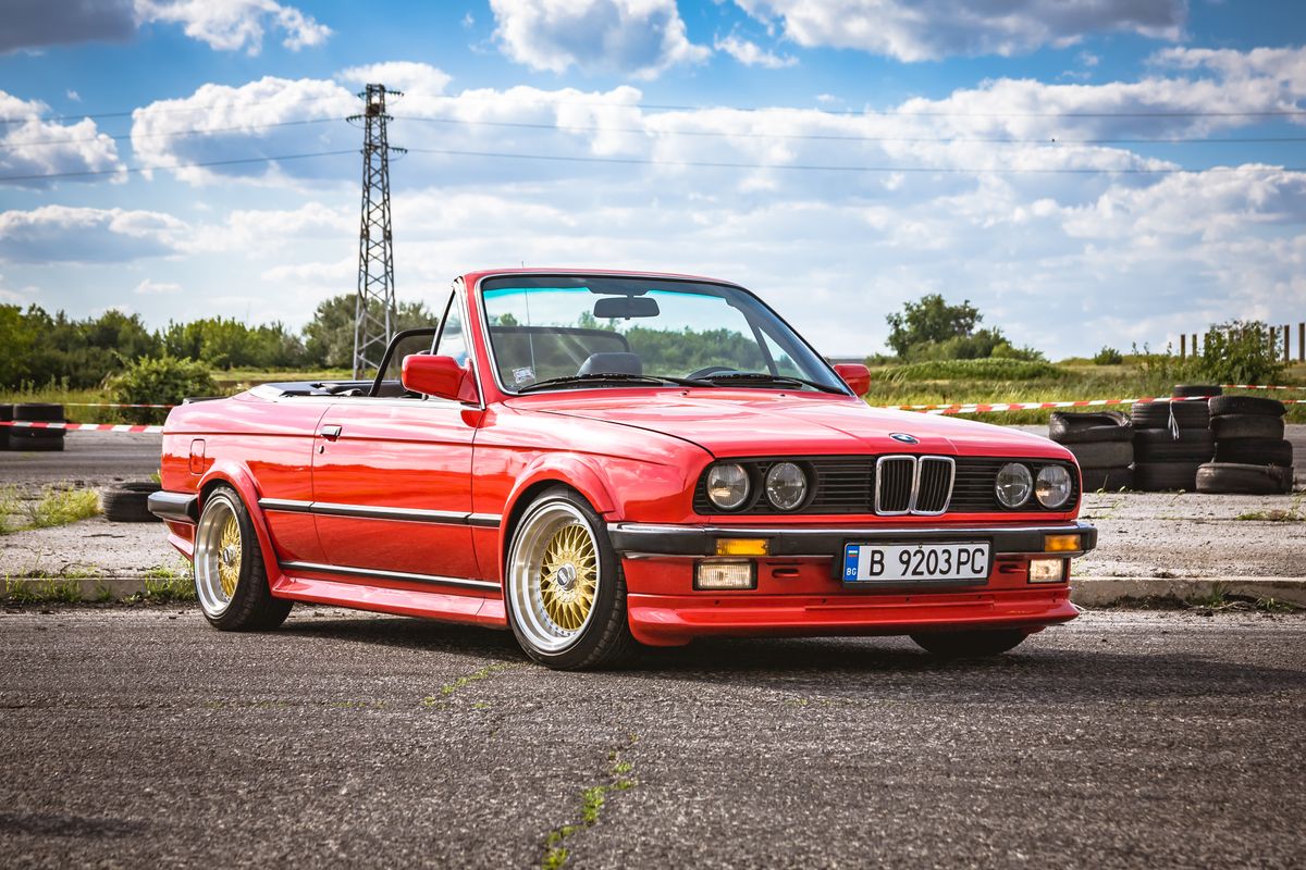 Varna, Bulgaria - September 25, 2018: BMW M3 E30 cabrio on race track ready to drift. LED headlights. Classic retro car. Old school. Wide fenders and BBS forged rims. Beautiful cloudy blue sky