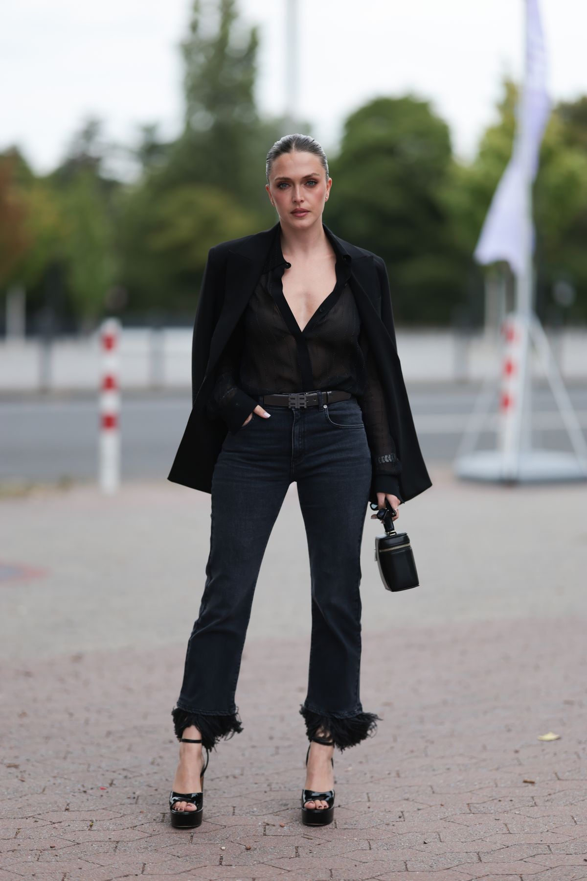 DUESSELDORF, GERMANY - JULY 19: Lauren Nikoi is seen wearing a black blazer, a sheer black blouse underneath, dark jeans, a rectangular black handbag, and high heels during the RIANI CRUISE 4.0. Dreamland at RSR Steiger Düsseldorf 1 on July 19, 2025 in Duesseldorf, Germany. (Photo by Jeremy Moeller/Getty Images for RIANI)