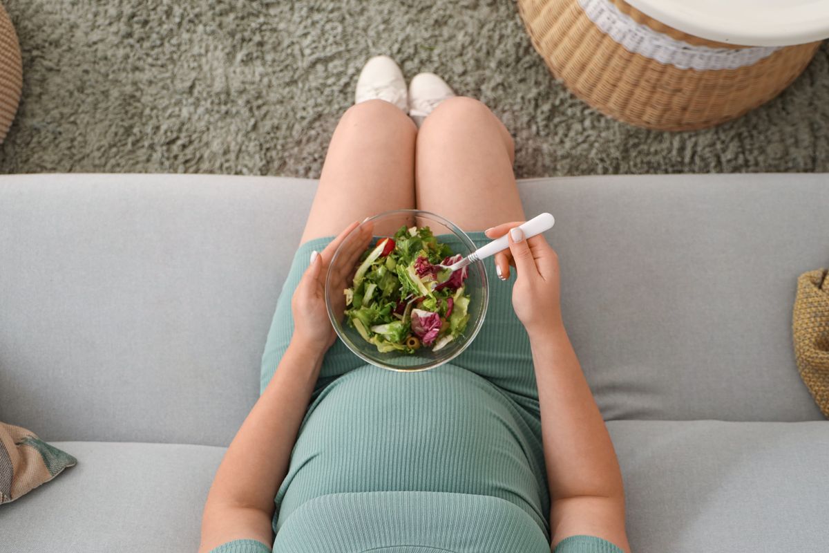 Kismamaétrend, egy várandós nő salátát fogyaszt.