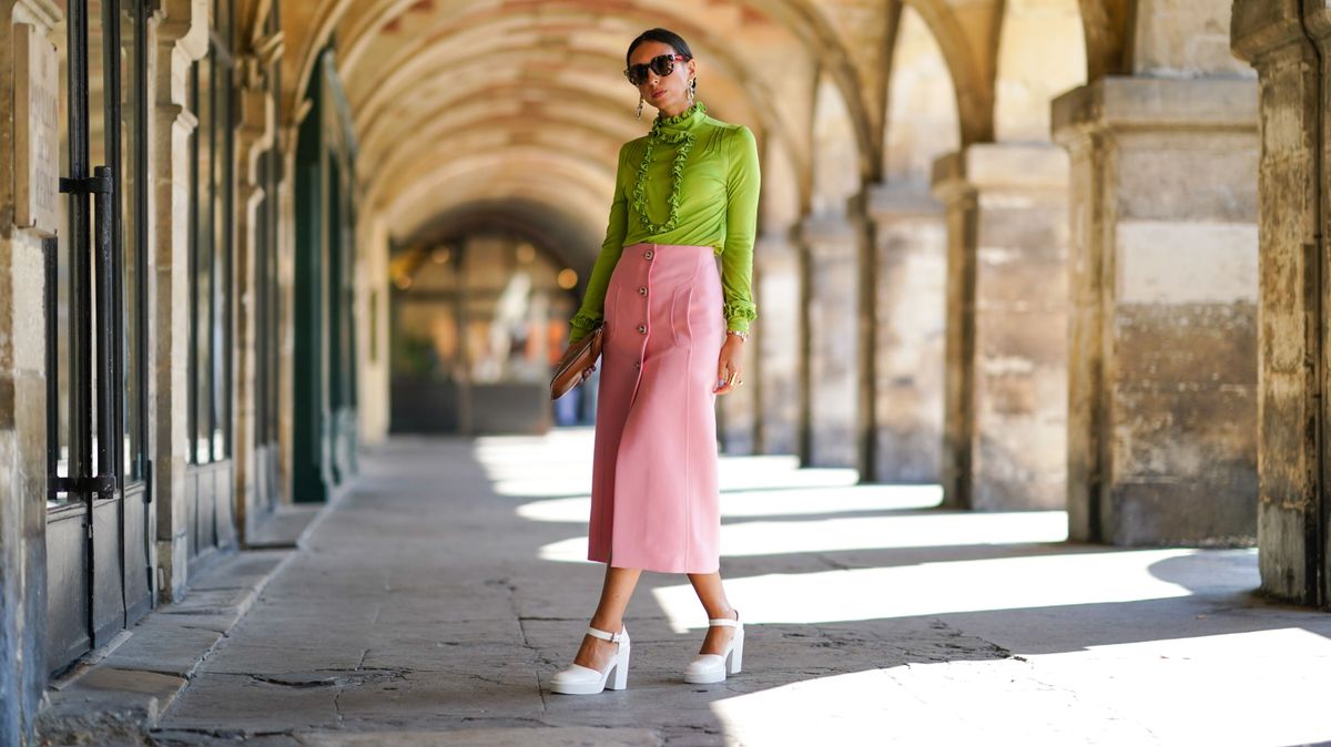tavaszi divat. PARIS, FRANCE - SEPTEMBER 22: Gabriella Berdugo wears a total look Prada, a green ruffle blouse with long sleeves, a pink pencil midi skirt with pockets, a brown leather pouch / clutch, white leather platform heels 60s style from Prada, sunglasses, on September 22, 2020 in Paris, France. (Photo by Edward Berthelot/Getty Images)