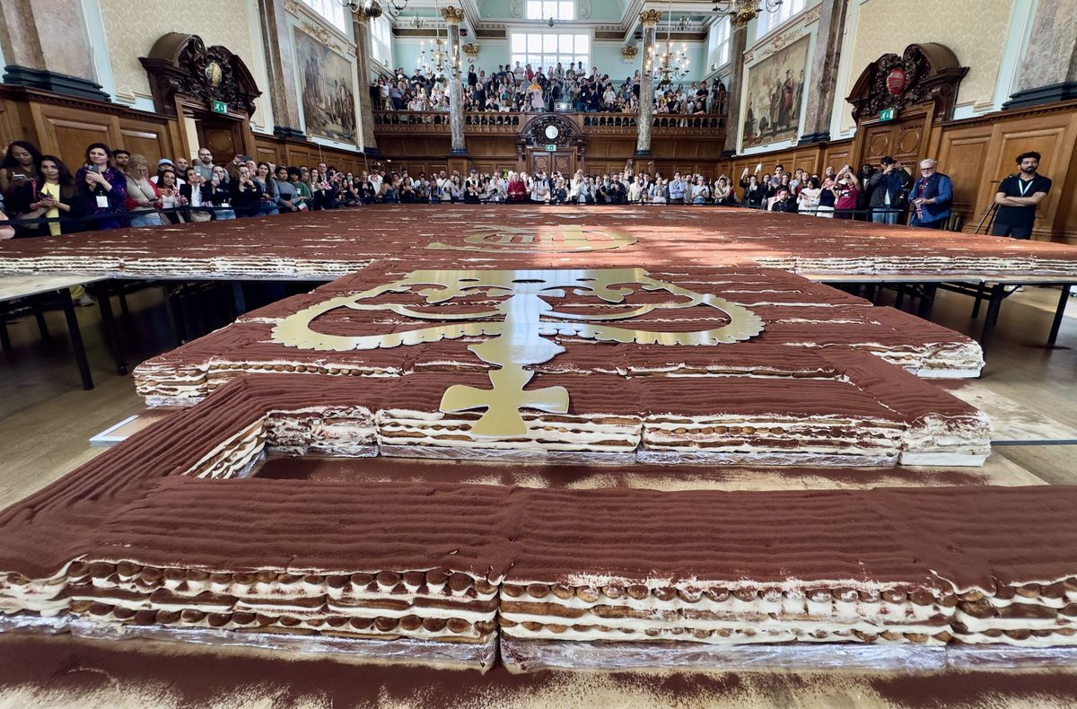 LONDON, UNITED KINGDOM - APRIL 26: A record-breaking tiramisu, measuring 440.58 meters, is displayed at Chelsea Old Town Hall in London, United Kingdom on April 26, 2026. Led by Italian entrepreneur Mirko Ricci and the London branch of the Federation of Italian Chefs, dozens of volunteers collaborated over two days to surpass the previous 273.5-meter record set in Milan in 2019. Guinness World Records official adjudicator Lorenzo Veltri verified the measurement on-site during the event, which was supported by the Italian Embassy and the Italian Cultural Institute. All proceeds from the organization were donated to the Esharelife Foundation to support efforts in combating poverty. Muhammed Yaylali / Anadolu (Photo by Muhammed Yaylali / Anadolu via AFP)