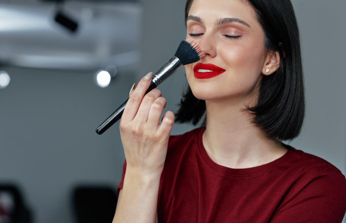 tartós smink: egy fiatal nő magát sminkeli