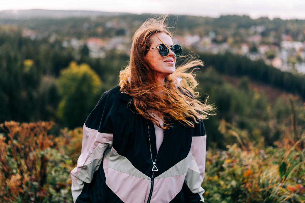 Az időjárásról szóló cikk képén vörös hajú nő áll a mezőn, haját és ruháját fújja a szél