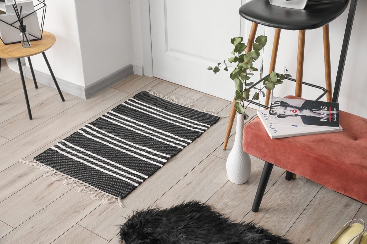 A fotón egy nappali látható, amit túl kicsi szőnyegekkel rendeztek be.