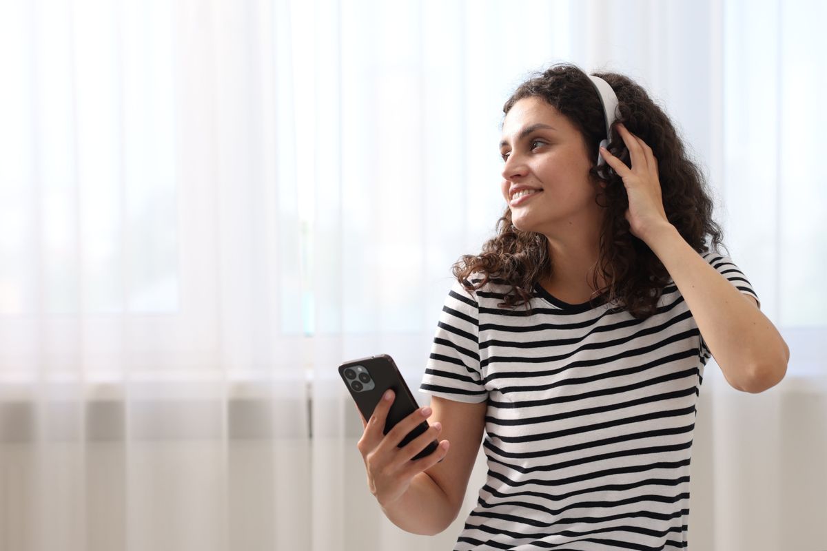A 2000-es évek slágerei kvíz kapcsán fejhallgatón keresztül hallgat dalokat a képen szereplő nő.