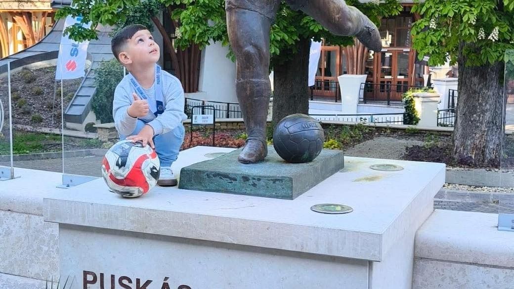 Puskás Ferenc szobra mellett guggol a futballikon ükunokája, Lucas.