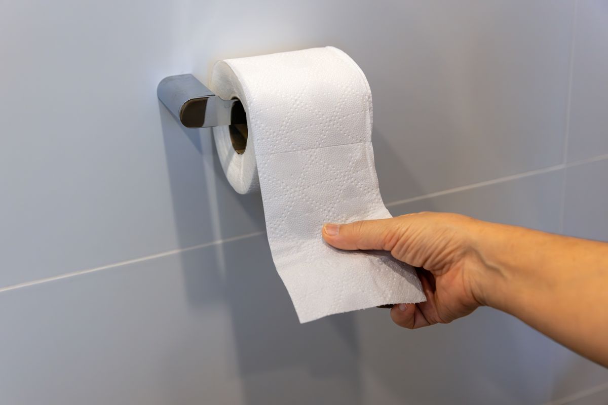 emlékezetkiesés vécézés után. A fotón egy wc papír tekercset használó kéz látható.