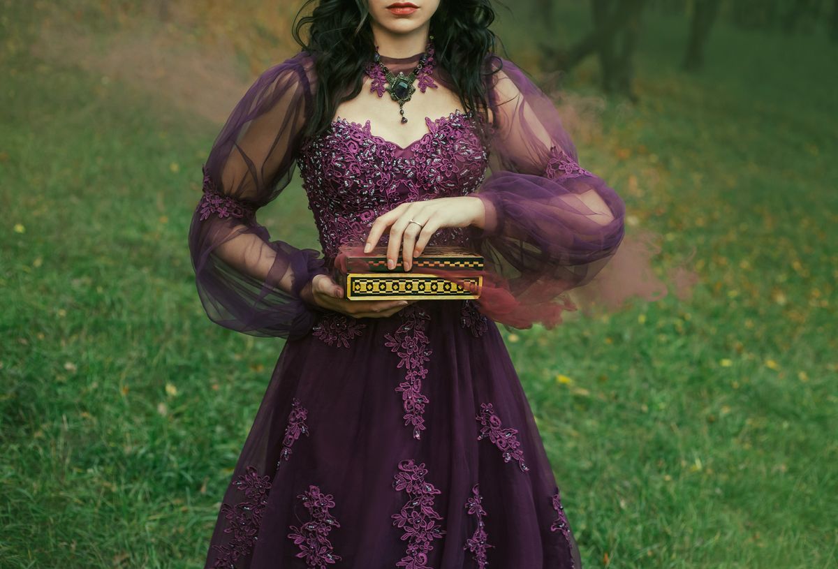 a dark-haired young lady holds in her hands an open Pandora's box, the red maroon thick fog of evil and disease slowly comes out, as a punishment for humanity. gothic image, art photo without a face