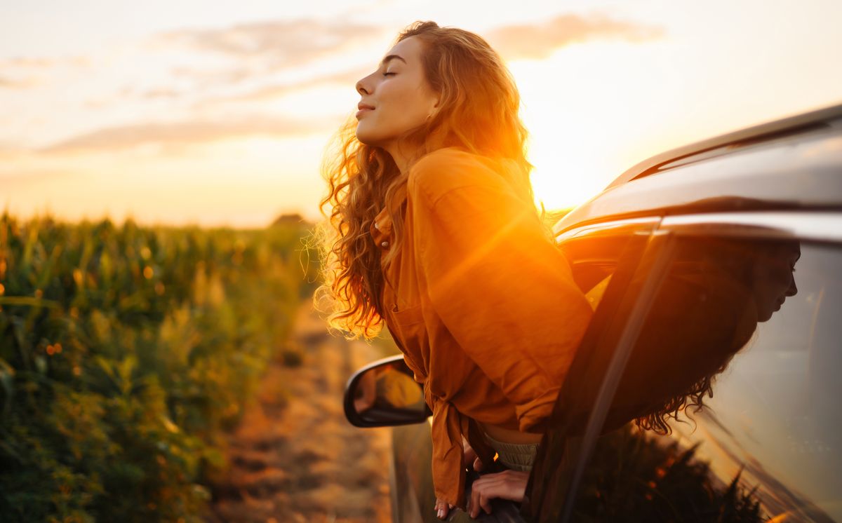 Towards adventure! Young woman is resting and enjoying the trip in the car.  Lifestyle, travel, tourism, nature, active life.
