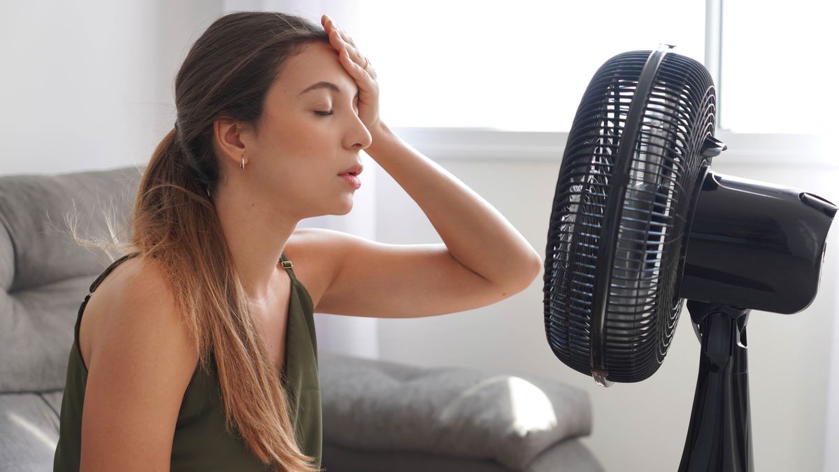 Ventillátrral hűti magát a kánikula alatt egy fiatal nő. 