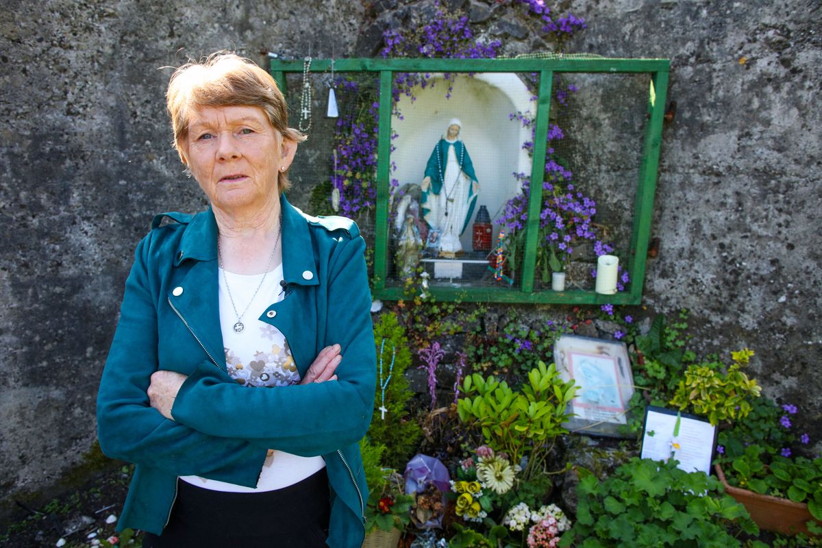 Historian Catherine Corless poses on the site of the former St Mary's Mother and Baby Home, in Tuam, in the outskirts of Galway, western Ireland, a site believed to be containing a mass grave of children and mothers, on May 20, 2025. St Mary's Mother and Baby Home was run by nuns from the Bon Secours order, Catherine Corless's research has uncovered that, between 1925 and 1961, 796 children died in the St Mary's Mother and Baby Home and are believed to be buried at this site some in large septic tanks. Over a decade since her findings, excavation crews will seal off the site on June 16, ahead of breaking ground the following month to search for remains. (Photo by Paul Faith / AFP)