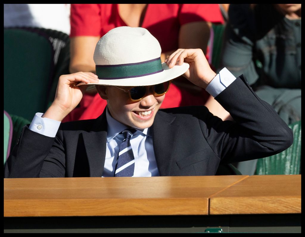 György herceg 2026. július 12-én a londoni Wimbledon-i teniszbajnokság utolsó napján: György herceg azon nevet, hogy felpróbált egy kalapot.