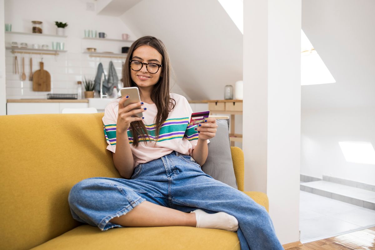 Beautiful young woman shopping online from home.