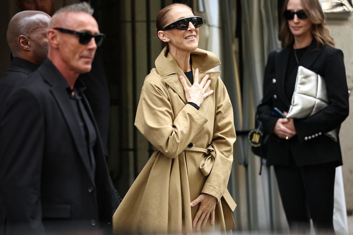 Canadian singer Celine Dion (C) acknowledges fans as she arrives at Hotel Le Royal Monceau in Paris on August 28, 2026, ahead of her series of concerts in the French capital. Celine Dion, 58, announced in late March, in a video and a message projected onto the Eiffel Tower, her return to the stage, in Paris, after six years away from the public, between the pandemic and persistent health problems. She has suffered since 2022 from stiff person syndrome, a rare and incurable neurological condition. (Photo by SIMON WOHLFAHRT / AFP)