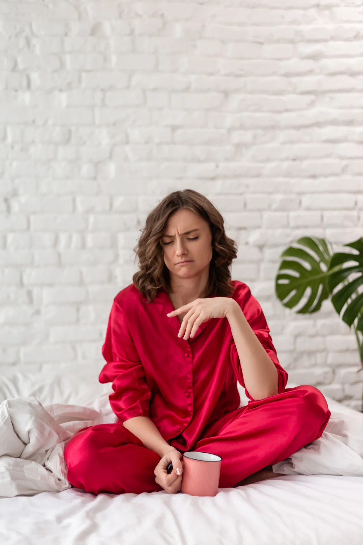 Tired,Angry,Woman,In,Pajamas,Sitting,On,The,Bed,In