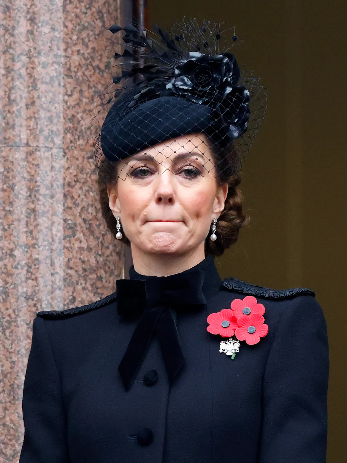 A képen Katalin hercegné összeszorított szájjal, feket kabátban.