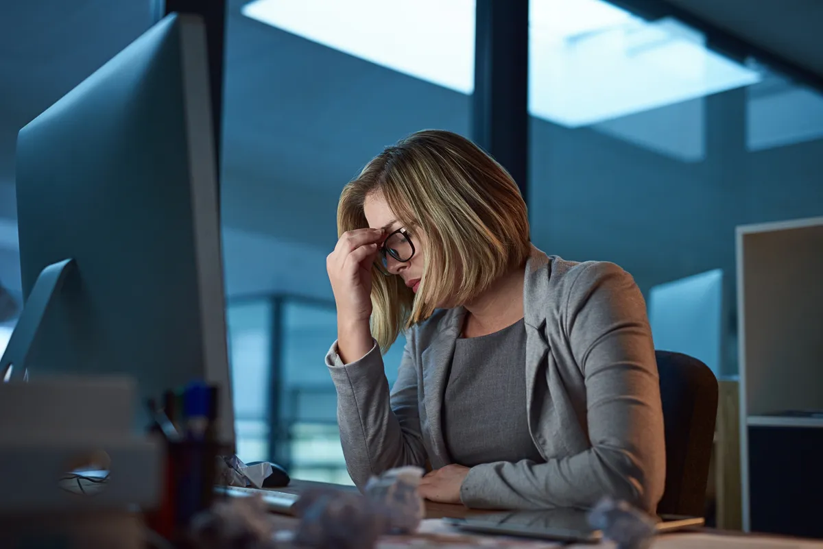 Headache, burnout and business woman in office, tired or fatigue while working late at night on computer. Stress, migraine and female person with depression, anxiety or brain fog, sick and deadline.