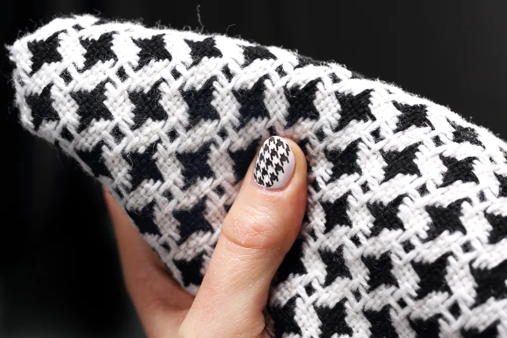 Klasszikus tyúklábminta textilen és körmön.