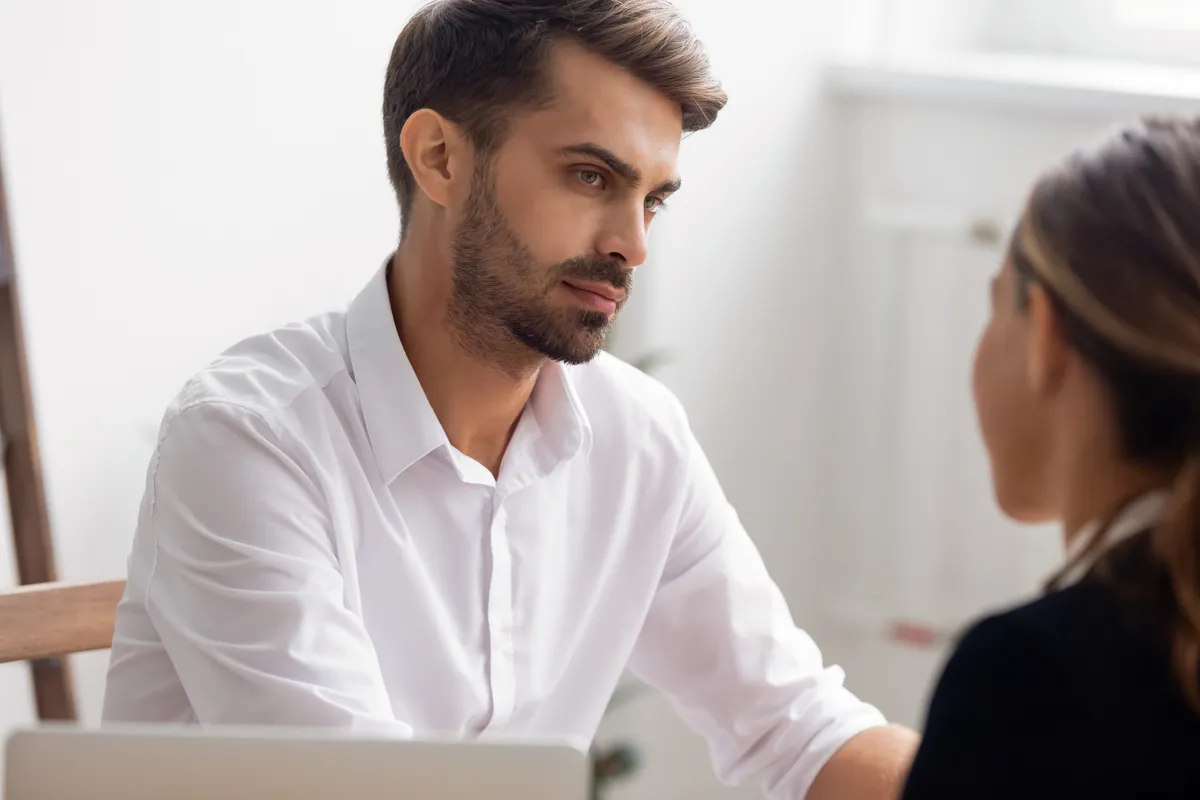 Serious hr manager attentively listening to candidate answering question on job interview in office close up, focused employer doubting, thinking about hiring decision, dishonest applicant or resume