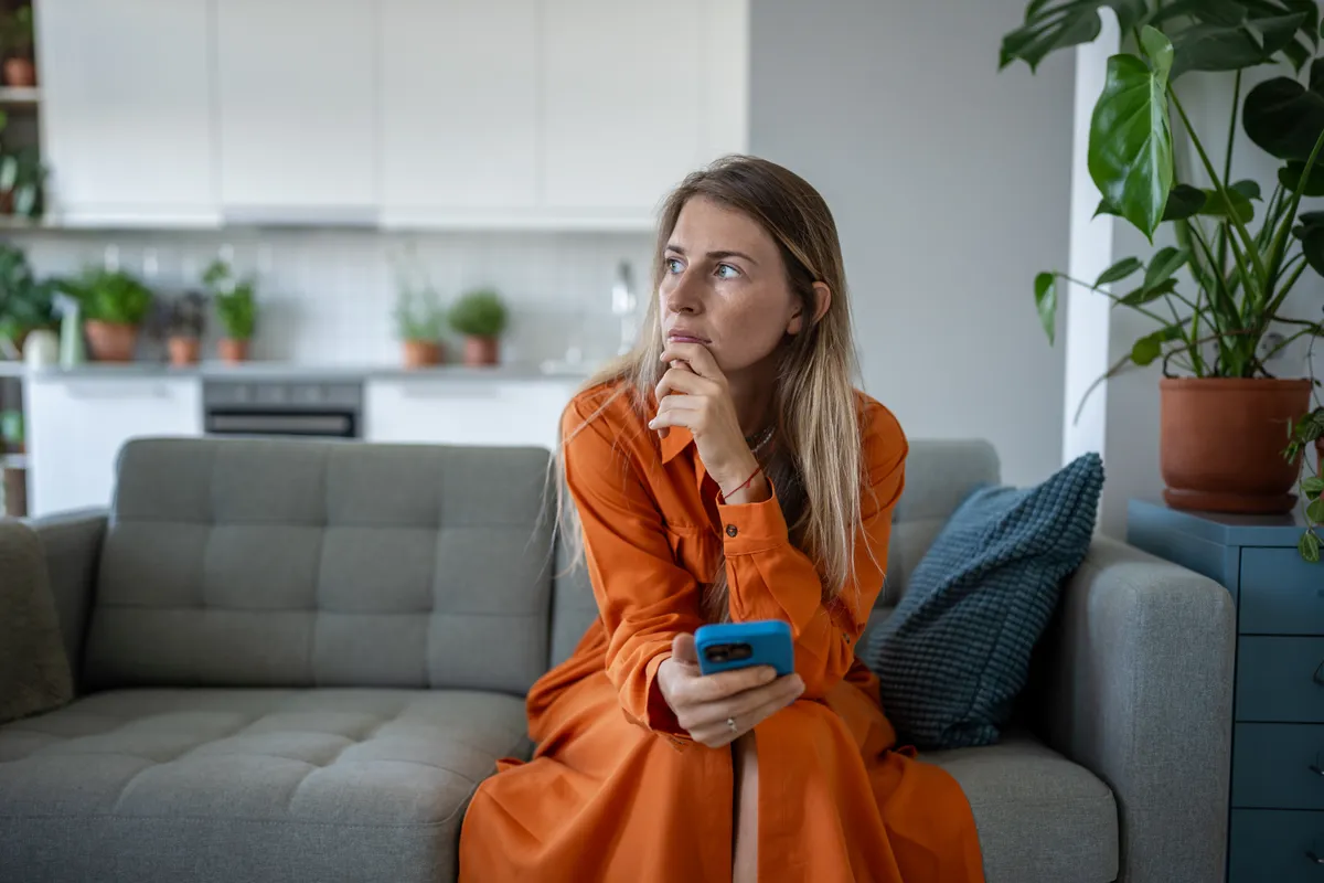 Nő a telefonján lévő IQ-teszten gondokodik