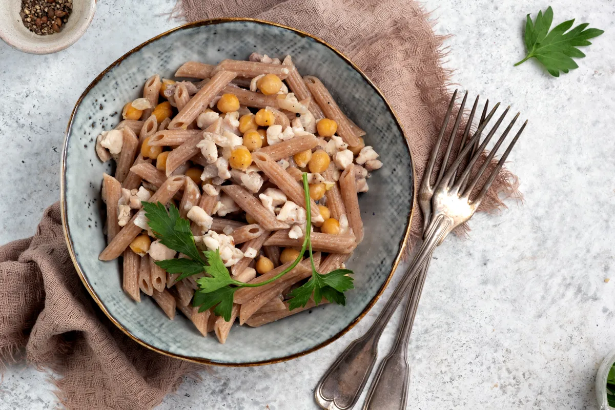 Spelt penne pasta with chicken and chickpeas. Healthy lunch or dinner meal