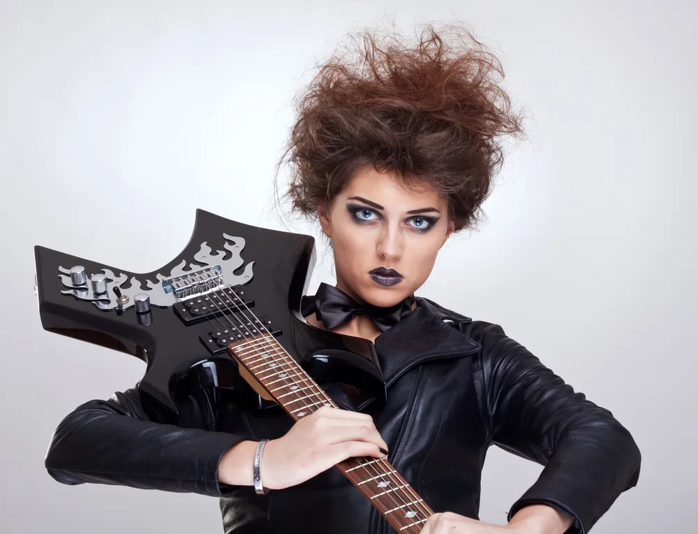 attractive woman guitarist holding her guitar on shoulder