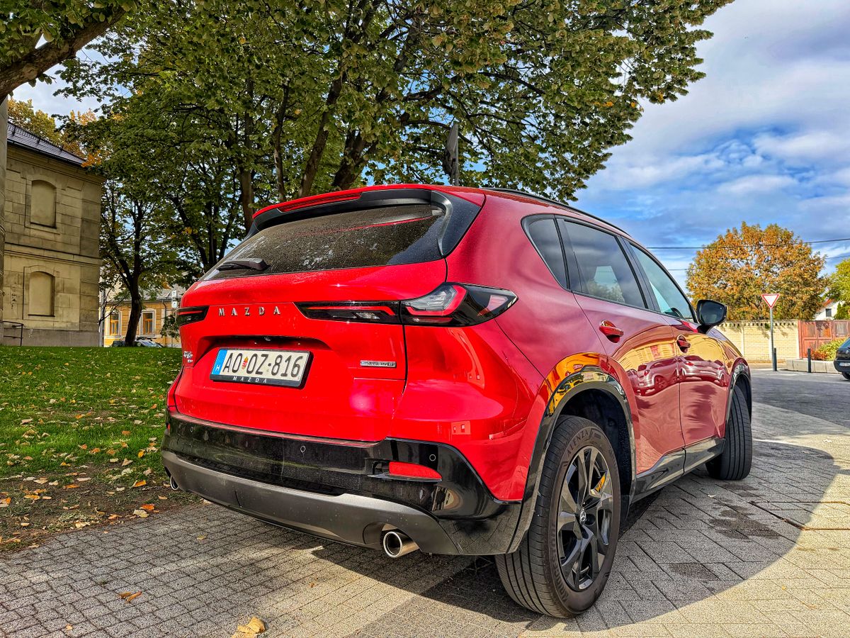 Soul Red Crystal piros Mazda CX-5 Homura Plus hátulnézetből, fekete keréktárcsákkal, új hátsó lámpákkal és Mazda felirattal, őszi környezetben.