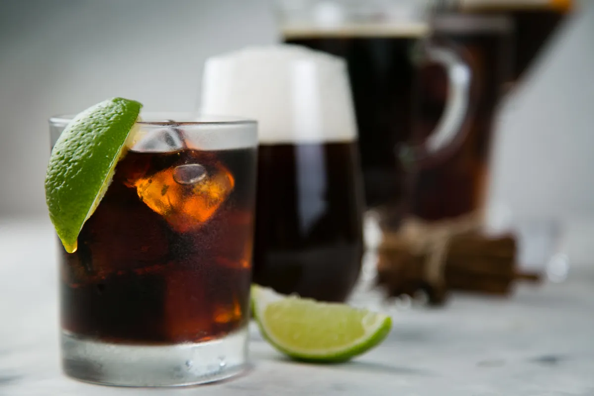 Selection of black cocktails in different glasses, marble background