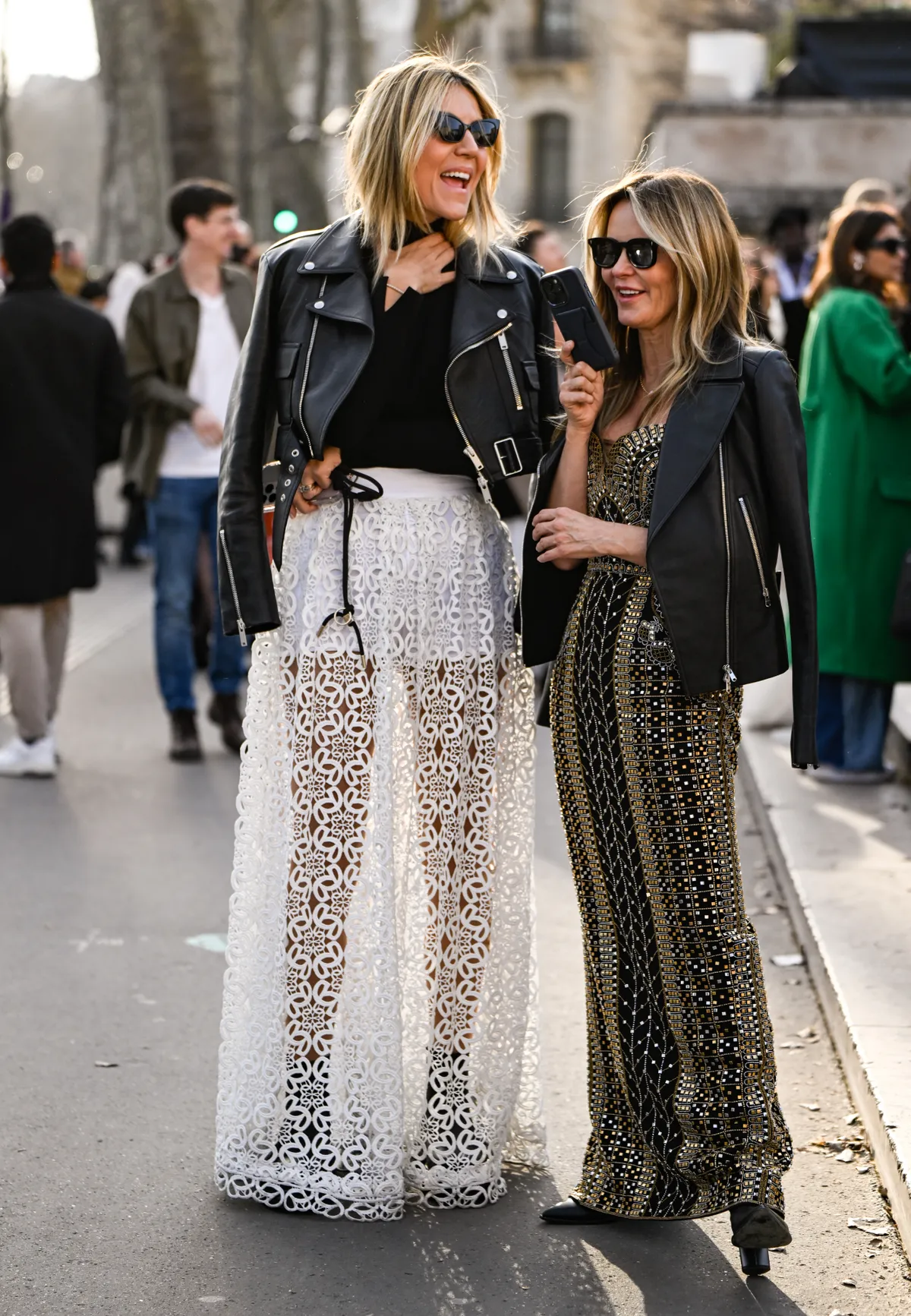 PARIS, FRANCE - MARCH 08: A guest is seen wearing a black leather jacket, black top, white laced skirt with a guest wearing a black leather jacket, gold and black Elie Saab dress and black sunglasses outside the Elie Saab show during the Womenswear Fall/Winter 2025/2026 as part of Paris Fashion Week on March 08, 2025 in Paris, France. (Photo by Daniel Zuchnik/Getty Images)