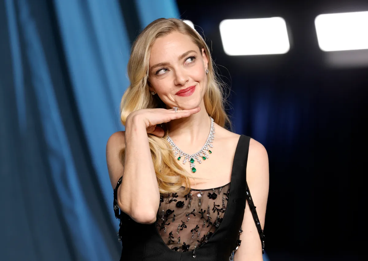 Amanda Seyfried egy fekete ruhában mosolyog egy filmszerep bemutatóján..