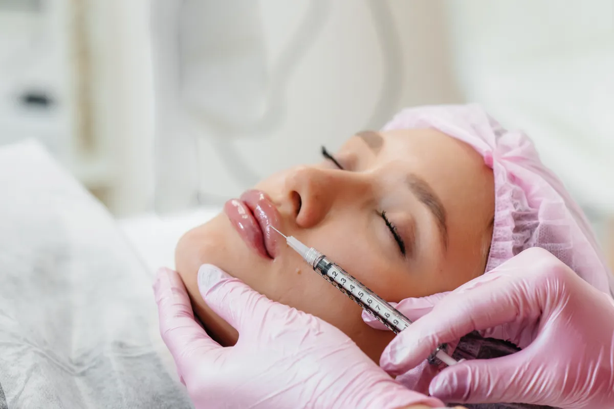 Cosmetology procedure for lip augmentation and wrinkle removal for a young beautiful girl. Cosmetology