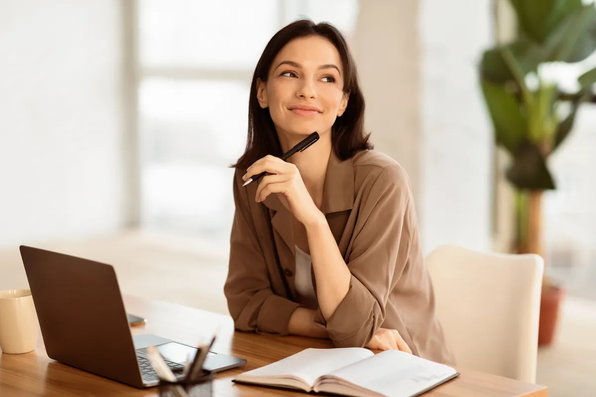 Dreaming About Vacation. Portrait of happy office worker thinking about holidays sitting at office, pondering, copyspace