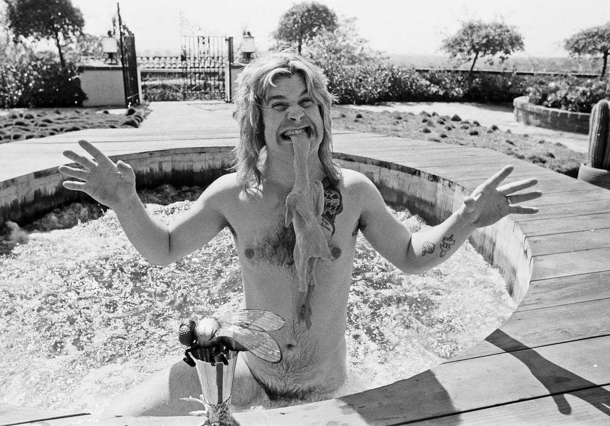 Ozzy Osbourne, former lead singer of Black Sabbath, pictured in his open air hot tub in the garden of his luxury home in Goldwater Canyon, Beverly Hills,California biting the head of a rubber chicken. 28th April 1982.(Photo by Eddie Sanderson/Getty Images).