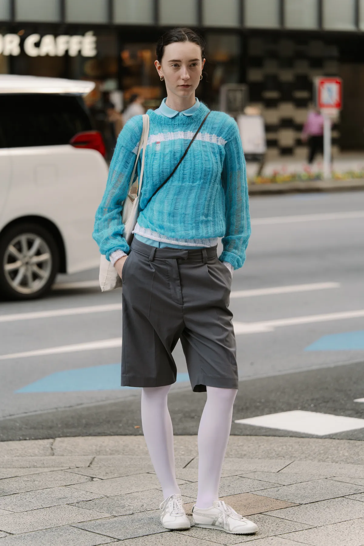 TOKYO, JAPAN - MARCH 22: A guest is seen wearing a blue top, grey shorts, white tights, Onitsuka Tiger white sneakers during Rakuten Tokyo Fashion Week A/W 2025 on March 22, 2025 in Tokyo, Japan. (Photo by Mila Gruber/Getty Images)
