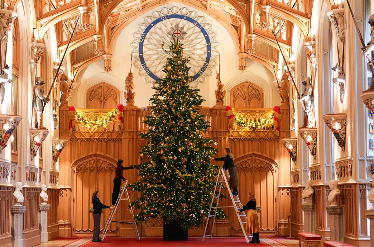 Royal Collection Trust staff add the finishing touches to a Christmas tree in St George's Hall, during a photo call for Christmas decorations at Windsor Castle, Berkshire, ahead of the festive season. Picture date: Thursday November 27, 2025.