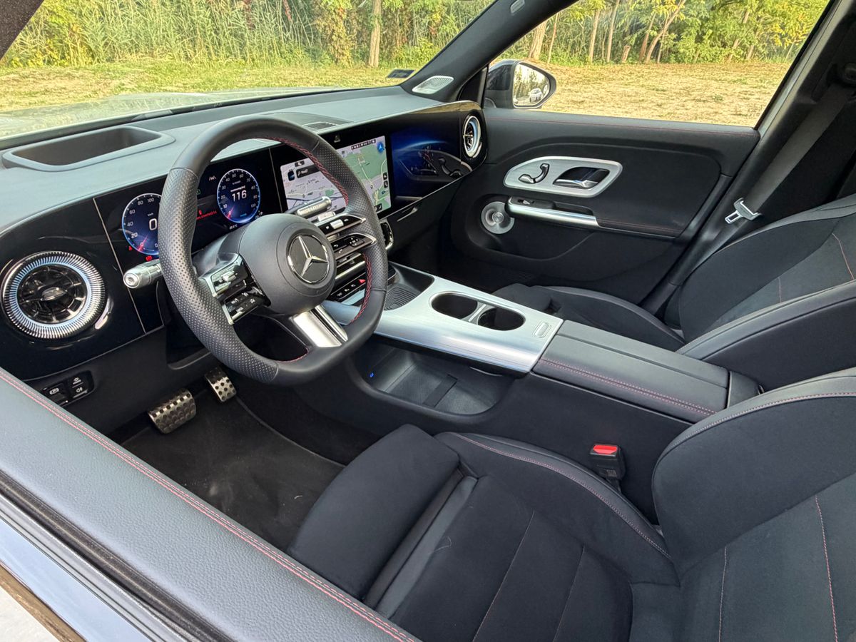 Mercedes-Benz GLB 250+ EQ AMG Line fekete utastere digitális műszerfallal, navigációs kijelzővel, sportkormánnyal és piros díszvarrású első ülésekkel.