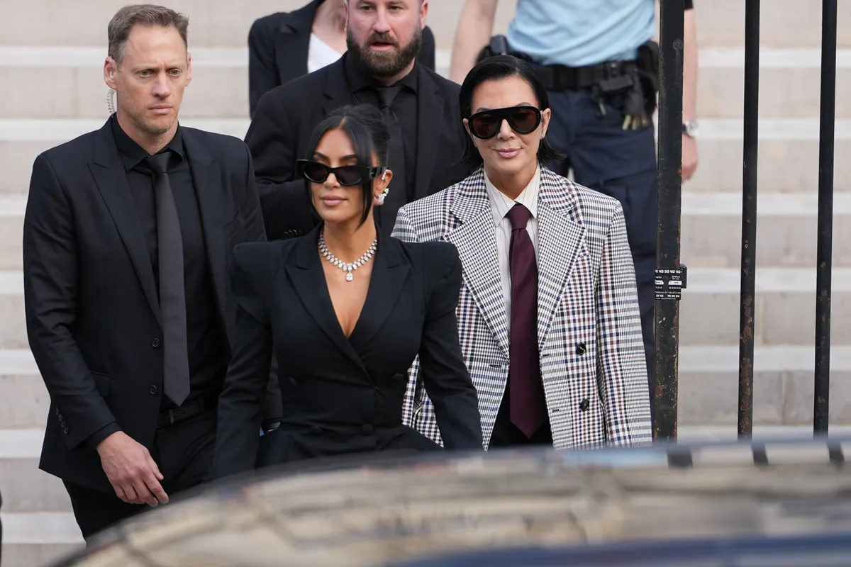 PARIS, FRANCE - MAY 13: Kim Kardashian and Kris Jenner exit the trial at the Palais de Justice ; Kim Kardashian wears sunglasses by Alaia, a black dress with power shoulders / shoulder pads / puff shoulders and low-neck by John Galliano, a necklace by Samer Halimeh, Repossi diamond earcuffs, Brioni Raymond earrings, at the Palais de Justice, on May 13, 2025 in Paris, France. (Photo by Edward Berthelot/GC Images)