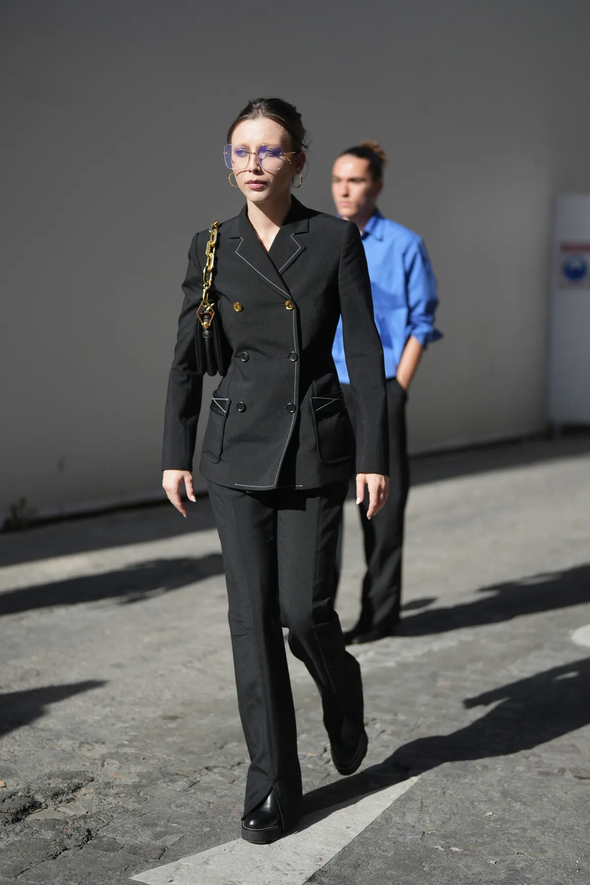 PARIS, FRANCE - OCTOBER 02: Emma Chamberlain wears glasses, earrings, a black double breasted blazer jacket, a leather bag, black pants, outside Louis Vuitton , during the Womenswear Spring/Summer 2024 as part of Paris Fashion Week on October 02, 2023 in Paris, France. (Photo by Edward Berthelot/Getty Images)